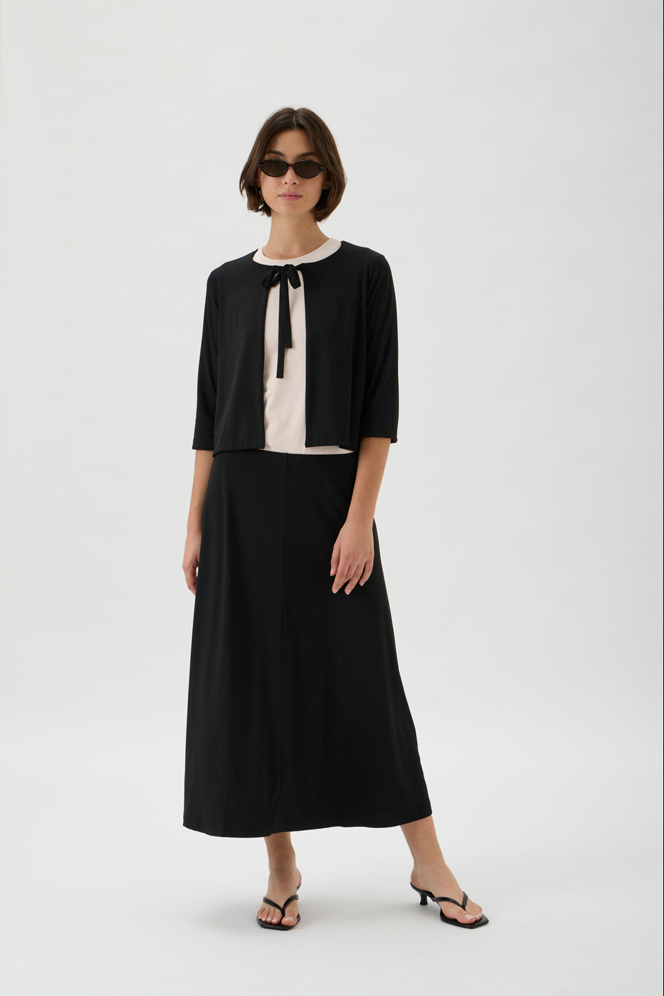 Minimalist Scandinavian black cardigan styled with flowing skirt