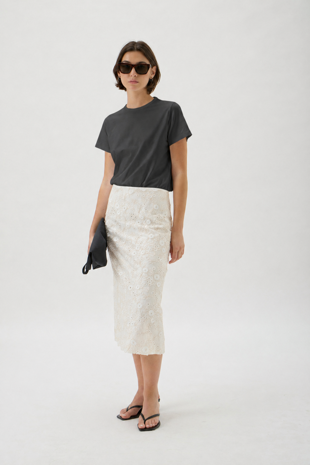 Black minimalist women’s T-shirt styled with embroidered ivory skirt and sunglasses