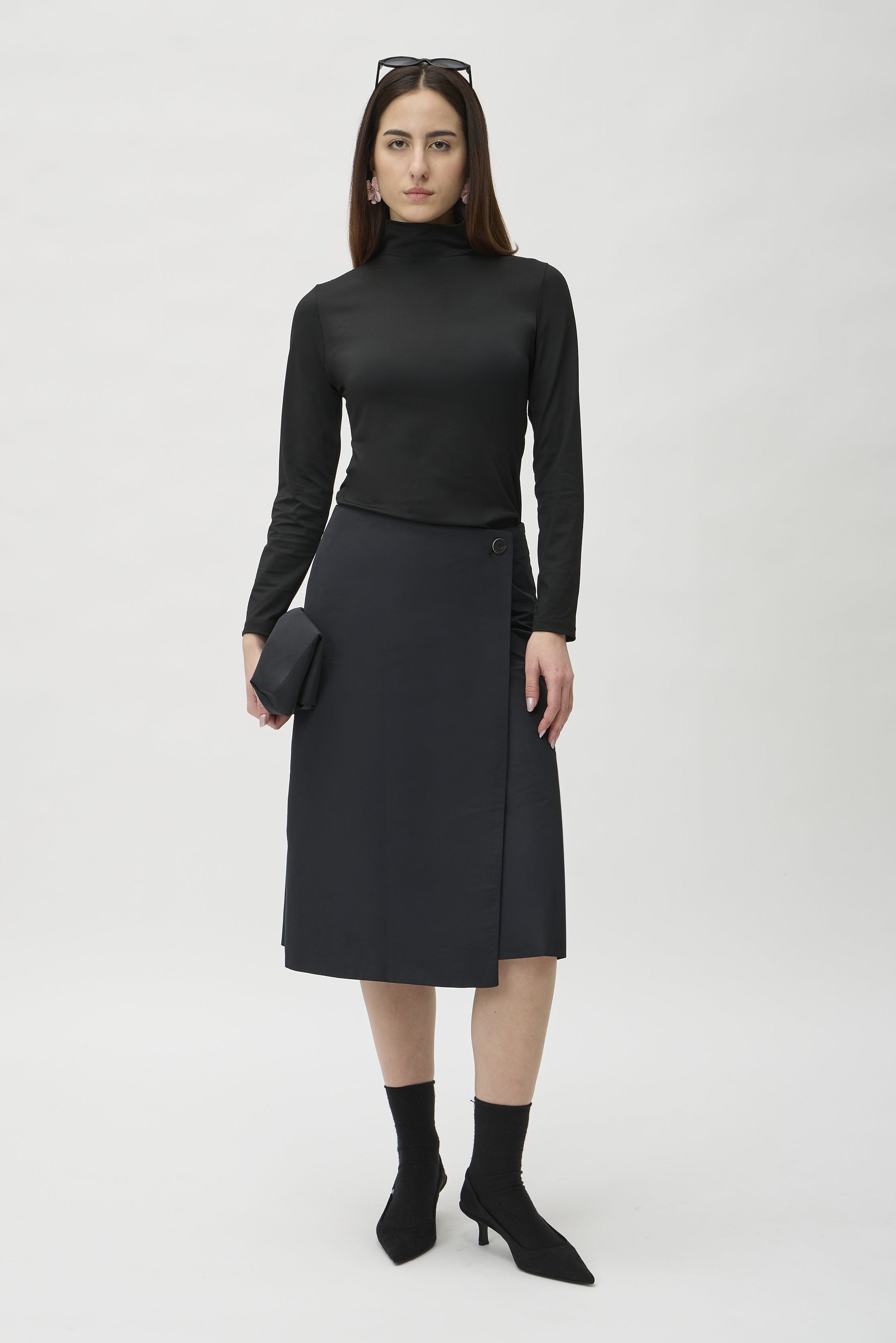 Wrap Skirt in Canguro 3363 Black – model front view with clutch bag – ELISE GUG