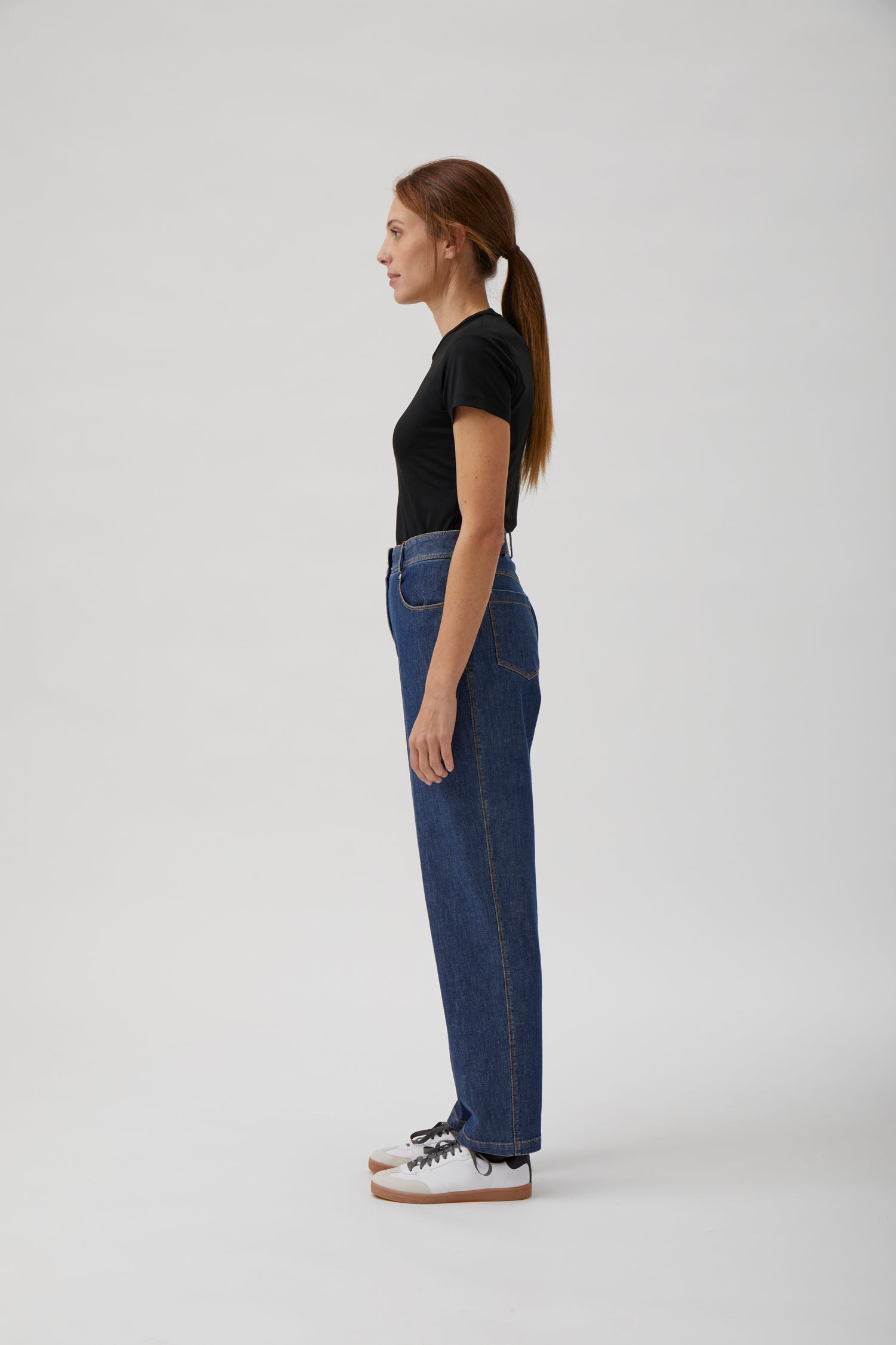 Side profile of luxury washed blue denim trousers by ELISE GUG